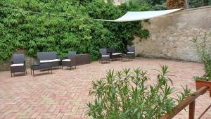 a group of chairs sitting on a brick patio at Milla Apartmanok in Eger
