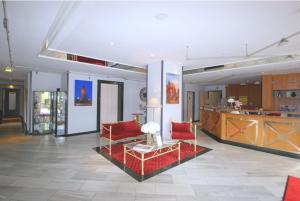 a living room with two red chairs and a table at Hotel Rosenstadt & Malxestube Restaurant in Noßdorf
