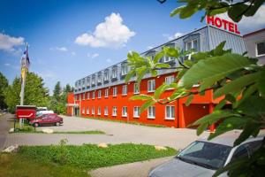 a red hotel with cars parked in front of it at Hotel Rosenstadt & Malxestube Restaurant in Noßdorf