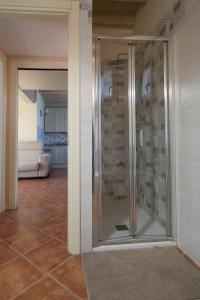 Una ducha de cristal en una habitación con sala de estar. en Garda Resort Village I Borghi en Peschiera del Garda
