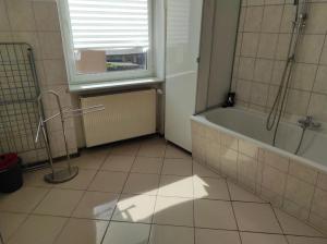 a bathroom with a tub and a window at Beautiful apartments in the city of zeitz in Zeitz