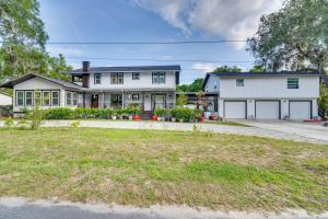 a large white house with a garage at Pet-Friendly Mt Dora Apartment with Deck - Near Lake in Mount Dora