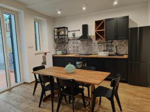 a kitchen with a wooden table and black cabinets at Luxury Berto Home in Taormina