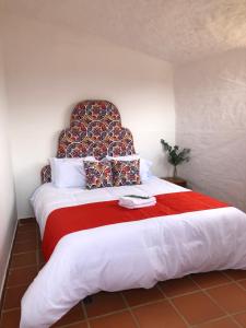 1 dormitorio con 1 cama grande con manta roja en Glamping Sierra de Luna en Villa de Leyva