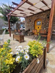 a patio with benches and flowers and a yellow door at Ilios Guest House in Gokceada Town