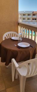 un tavolo con due sedie bianche e una tovaglia marrone di Apartamento 232 Gs International a Costa Del Silencio
