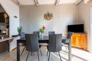 a dining room with a black table and chairs at Maison Climatisée Vue Mer in Carry-le-Rouet