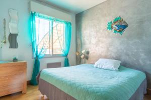 ein Schlafzimmer mit einem Bett, einer Kommode und einem Fenster in der Unterkunft Maison Climatisée Vue Mer in Carry-le-Rouet