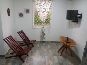 聖貝爾納多德爾比恩托的住宿－Cabaña frente al mar Encanto del Viento，一间设有两把椅子、一张桌子和一台电视的房间