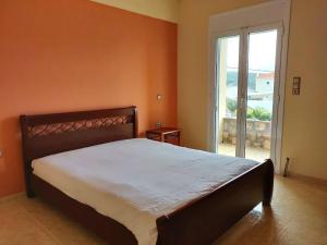 1 dormitorio con cama grande y ventana grande en Dimitris Vasos Villa With Sea And Mountain View, en Aliveri