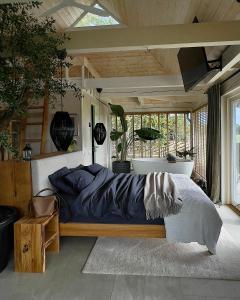 Nordicstay Noarootsi Kastehein or Loojangu villa في Paslepa: غرفة نوم مع سرير مع لحاف أزرق