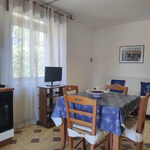 a dining room with a table and chairs and a television at Casa Relax Acqua Marina in Favignana