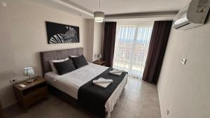 - une chambre avec un lit et une grande fenêtre dans l'établissement ArdorMare Hotel, à Alanya