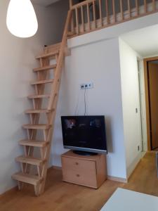 a living room with a staircase and a tv at Loft style apartments in Kaunas center in Kaunas