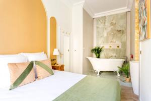 - une chambre avec un lit blanc et une baignoire dans l'établissement Luxury 5 Bedroom 4 Bathroom - Louvre & Notre Dame, à Paris