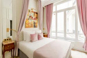 - une chambre avec un lit blanc et une fenêtre dans l'établissement Luxury 5 Bedroom 4 Bathroom - Louvre & Notre Dame, à Paris