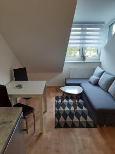 a living room with a blue couch and a table at Loft style apartments in Kaunas center in Kaunas