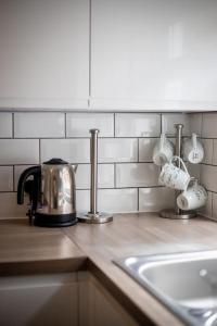 a kitchen counter with a tea kettle and coffee cups at The Royalty in Sunderland