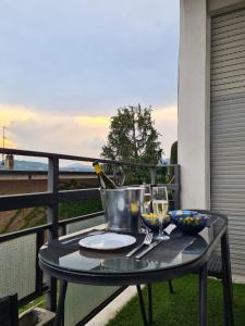 una mesa con una botella de vino y copas en el balcón en Casa Vacanza Luce en Como