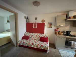 salon z kanapą i kuchnią w obiekcie LA CASA DI PUCCI nel borgo affrescato di PARLASCO w mieście Cortenova