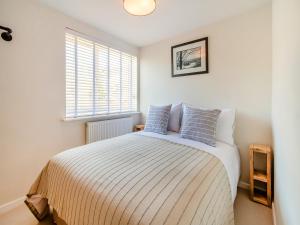 a bedroom with a large bed with a window at Kew Cottage in Brotton