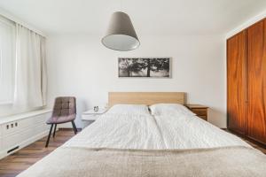 1 dormitorio con 1 cama grande y 1 silla en FeelHome-Karmeliterviertel-6 Gäste-WiFi-Smart TV, en Viena