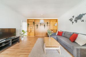 Sala de estar con sofá gris y mesa en FeelHome-Karmeliterviertel-6 Gäste-WiFi-Smart TV, en Viena