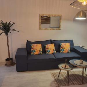 un sofá azul con almohadas en la sala de estar en Apartament Punta Prima, en Torrevieja