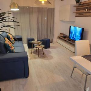 sala de estar con sofá y TV de pantalla plana en Apartament Punta Prima, en Torrevieja