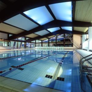 een groot binnenzwembad met een groot plafond bij Apartments Montblanc Sella in Ortisei