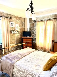 維塞烏的住宿－Casa Castenda，一间卧室配有床、电视和窗帘