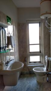 a bathroom with a sink and a toilet and a window at Yuru Retreat Delo in Kalimpong