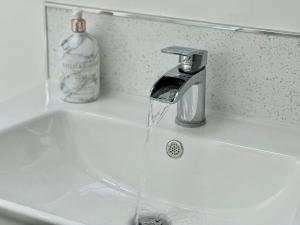 ein Waschbecken mit Wasser aus einem Wasserhahn in der Unterkunft 7 Blue bridge Luxury Loft Apartment with private parking in York