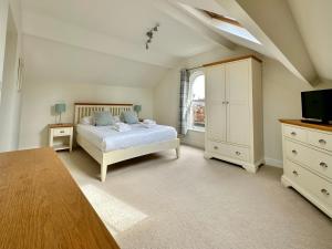 ein Schlafzimmer mit einem Bett, einer Kommode und einem TV in der Unterkunft 7 Blue bridge Luxury Loft Apartment with private parking in York