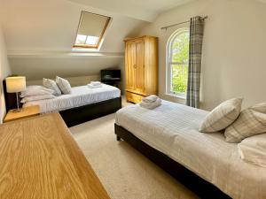 1 Schlafzimmer mit 2 Betten und einem Fenster in der Unterkunft 7 Blue bridge Luxury Loft Apartment with private parking in York