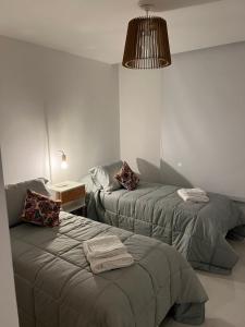une chambre d'hôtel avec deux lits et une lampe dans l'établissement Departamento moderno 3 ambientes con cochera, à Mar del Plata