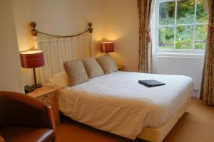 a bedroom with a bed with a book on it at Waveney House Hotel in Beccles