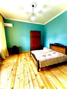 a bedroom with a bed and a wooden floor at Дом с 5 спальнями в Батуми in Batumi