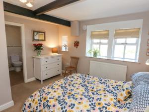 a bedroom with a bed and a dresser and windows at Piccadilly View in Keighley