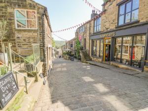 a cobblestone street in an old town with buildings at Piccadilly View in Keighley