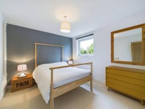 1 dormitorio con 1 cama, vestidor y ventana en Stylish Cotswold Parking Peaceful Garden en Winchcombe