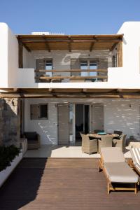 a patio with chairs and a table on a building at Amaris Mykonian Residence in Ornos
