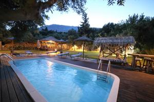 een zwembad met banken en een tafel en stoelen bij Captain Ikaros in Agios Kirykos
