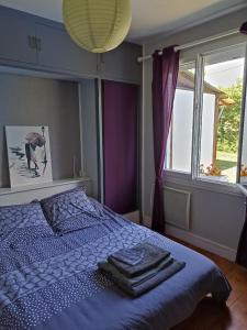ein Schlafzimmer mit einem blauen Bett und Handtüchern darauf in der Unterkunft Maison de village en bord de rivière in Narcy