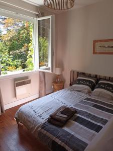 ein Schlafzimmer mit einem Bett und einem großen Fenster in der Unterkunft Maison de village en bord de rivière in Narcy