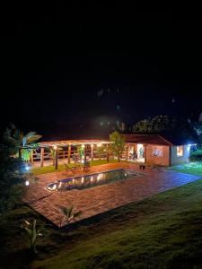 a building with a swimming pool at night at Pousada Chales da Canastra in Vargem Bonita