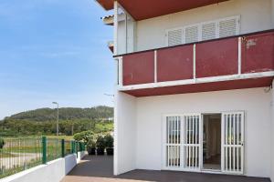 ein weißes und rotes Gebäude mit einem Balkon in der Unterkunft Casa Vasconcelos in Afife