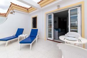 un patio con sedie blu e tavolo e sedie bianchi di Terrace View Studio ad Adeje