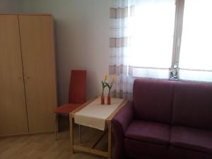 a living room with a table and a purple couch at Ferienwohnung Wilhelmi in Saarburg