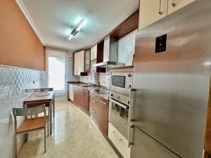 a kitchen with a stainless steel refrigerator and a table at Abad Paterno - 3008 in Santoña